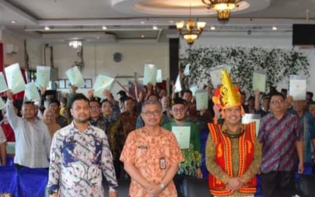 Foto: Saat Kepala BPN Kabupaten Nias, Sekda Kabupaten Nias dan Anggota DPR RI Komisi II (kiri-kanan) foto bersama masyarakat penerima sertifikat tanah.