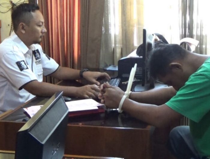 Foto: Pelaku pencabulan terhadap putri tirinya berinisial EW (19) warga Kecamatan Semboro, Kabupaten Jember, tampak lesu di hadapan penyidik.