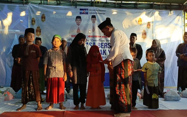 Foto: Ketua DPC Partai Demokrat Sumenep, Indra Wahyudi, saat menyerahkan santunan kepada puluhan anak yatim dalam kegiatan buka bersama seluruh kader. (Foto Istimewa)