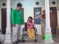 FOTO: Pimpinan 4 Baznas Sumenep, A. Rahman saat menyerahkan bantuan kursi roda untuk Siti Nur Aisa, siswi sekolah dasar di Kecamatan Batu Putih.