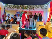 Foto: Kepala Desa Lobuk Moh Saleh saat menyerahkan santunan kepada anak yatim perwakilan empat dusun, JJS momentum HUT kemerdekaan ke-79 Republik Indonesia, di wisata spot pancing pantai matahari.
