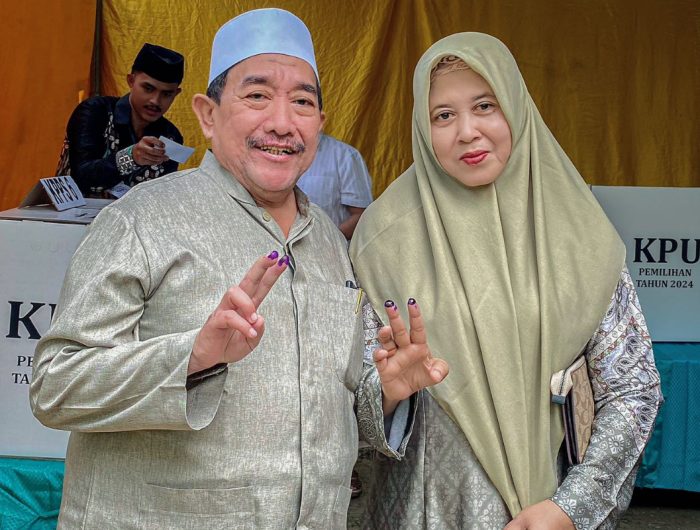 FOTO: Calon Wakil Bupati (Cawabup) KH. Imam Hasyim, didampingi sang istri saat menggunakan hak pilihnya di TPS 002 Desa Aengbaja Raja, Rabu (27/11/2024).