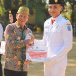 Foto: Pj Bupati Pamekasan, Masrukin saat menyerahkan penghargaan kepada anggota Paskibraka berprestasi dalam upacara Hari Sumpah Pemuda 2024.