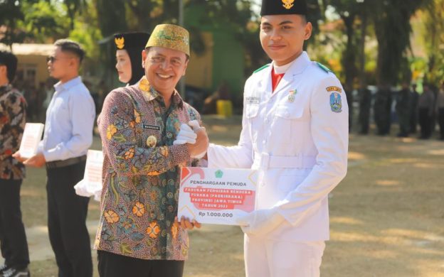 Foto: Pj Bupati Pamekasan, Masrukin saat menyerahkan penghargaan kepada anggota Paskibraka berprestasi dalam upacara Hari Sumpah Pemuda 2024.