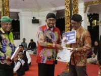 FOTO: Bupati Sumenep Achmad Fauzi Wongsojudo saat menyerahkan penghargaan kepada para seniman dan budayawan di Pendopo Agung Keraton, Kamis (28/11/2024) malam.