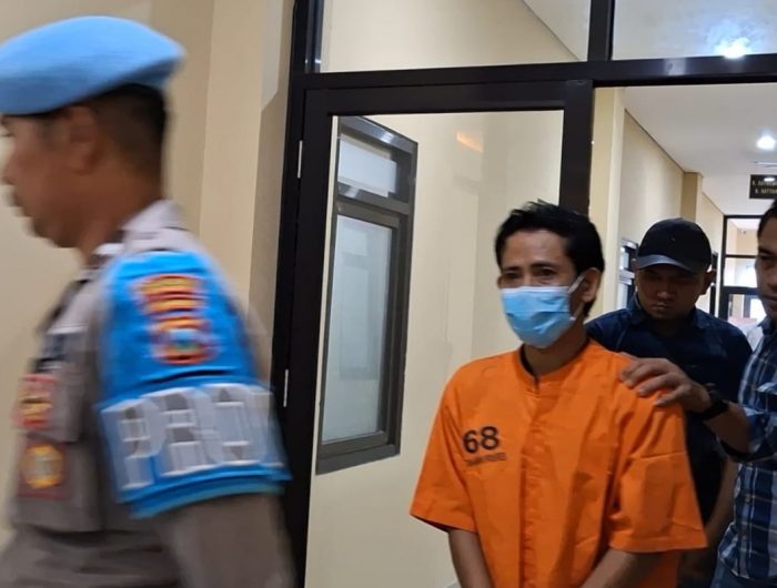 FOTO: Oknum anggota DPRD Kabupaten Sumenep memakai baju orange digelandang petugas usai konferensi pers di Mapolres Sumenep. Kamis (5 Desember 2024) sore. (Panji Agira/wartazone.com)