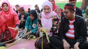 FOTO: Bupati Sumenep, H. Achmad Fauzi Wongsojudo bersama istri Hj. Nia Kurnia Fauzi saat membuat ketupat dalam Festival Ketupat 2025, di Pantai Slopeng Kecamatan Dasuk, Senin (7 April 2025).