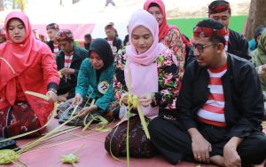 FOTO: Bupati Sumenep, H. Achmad Fauzi Wongsojudo bersama istri Hj. Nia Kurnia Fauzi saat membuat ketupat dalam Festival Ketupat 2025, di Pantai Slopeng Kecamatan Dasuk, Senin (7 April 2025).