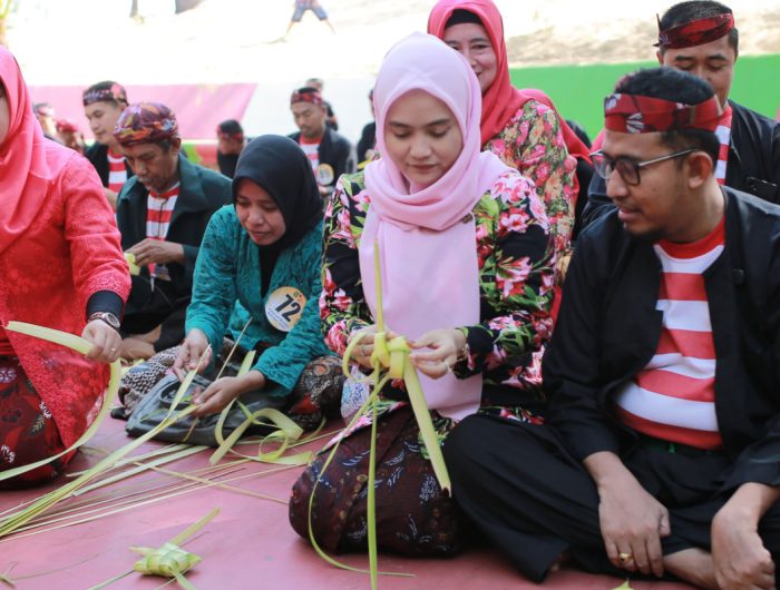 FOTO: Bupati Sumenep, H. Achmad Fauzi Wongsojudo bersama istri Hj. Nia Kurnia Fauzi saat membuat ketupat dalam Festival Ketupat 2025, di Pantai Slopeng Kecamatan Dasuk, Senin (7 April 2025).