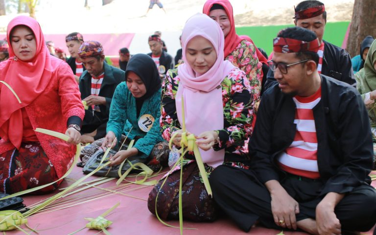 FOTO: Bupati Sumenep, H. Achmad Fauzi Wongsojudo bersama istri Hj. Nia Kurnia Fauzi saat membuat ketupat dalam Festival Ketupat 2025, di Pantai Slopeng Kecamatan Dasuk, Senin (7 April 2025).