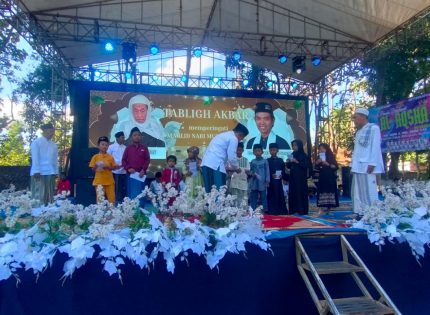 FOTO: Ketua Baznas Sumenep Ahmad Rahman, saat menyerahkan santunan anak yatim dalam gelaran Tabligh Akbar dan Pengajian Umum yang berlangsung di Lapangan Dusun Tengah, Desa Romben Guna, Minggu (20/07/2025).
