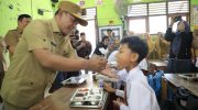 FOTO: Wakil Bupati (Wabup) Pamekasan H. Sukriyanto menyuapi salah satu siswa saat meninjau program Makan Bergizi Gratis (MBG) di SDN Laden 1, Senin (14/4/2025).