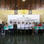 FOTO: Bupati Pamekasan, KH. Kholilurrahman menyerahkan secara simbolis bantuan jeriken BBM bersubsidi dan kartu BPJS Ketenagakerjaan kepada nelayan, Rabu (11/6/2025)