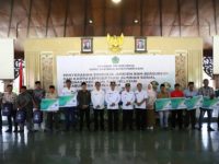 FOTO: Bupati Pamekasan, KH. Kholilurrahman menyerahkan secara simbolis bantuan jeriken BBM bersubsidi dan kartu BPJS Ketenagakerjaan kepada nelayan, Rabu (11/6/2025)