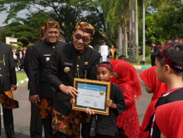 FOTO: Bupati Pamekasan, Dr. KH. Kholilurrahman, menyerahkan penghargaan kepada pelajar berprestasi usai upacara Hari Pendidikan Nasional (Hardiknas) 2026 di halaman Kantor Bupati Pamekasan, Senin (4/5/2026).