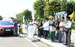 FOTO: Wakil Bupati Sumenep, KH. Imam Hasyim, saat melepas keberangkatan Jemaah Shalawat Nariyah Kabupaten Sumenep untuk menghadiri Haul Masyayikh se-Nusantara di Alun-Alun Kabupaten Situbondo, Sabtu (18/7/2026).